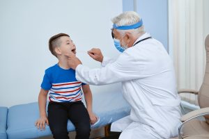 Médico examinando boca de criança